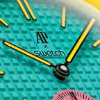 Détail cadran Royal Pop OTG ROZ — motif Tapisserie turquoise, logo AP x Swatch, aiguilles jaunes Super-LumiNova, couronne jaune à 3h